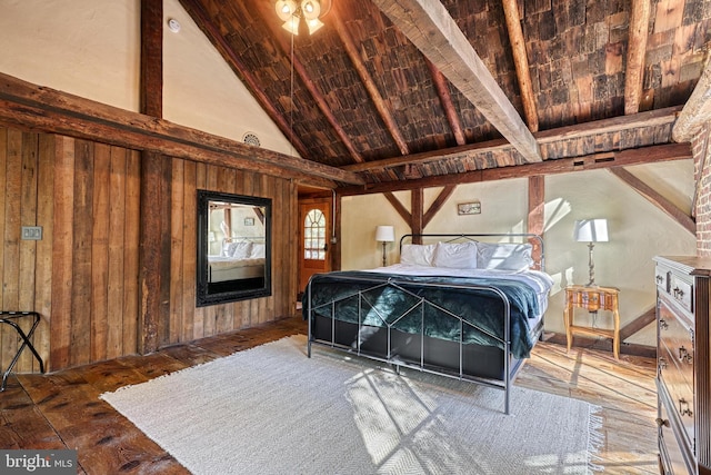 bedroom featuring vaulted ceiling with beams, dark hardwood / wood-style floors, and wooden walls