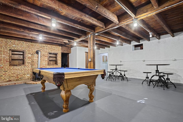 playroom with a wood stove, brick wall, concrete flooring, and billiards