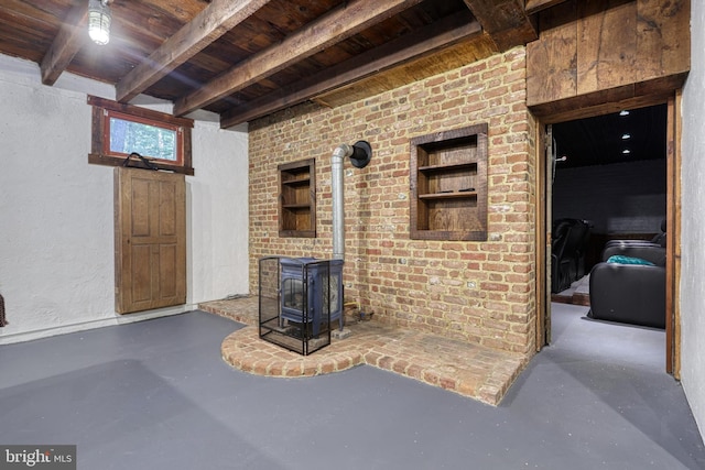 living room with concrete floors, a wood stove, and wooden ceiling