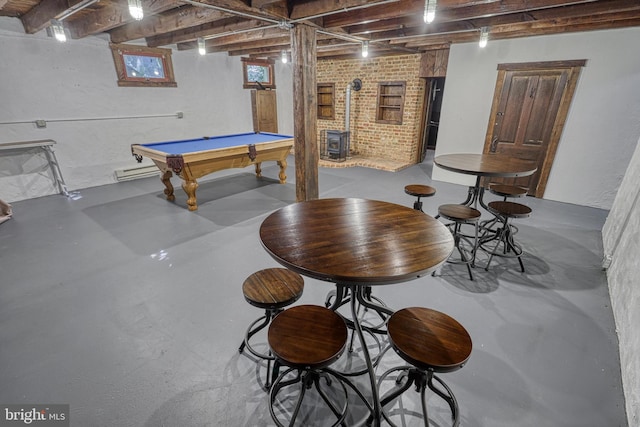 recreation room with a wood stove, billiards, brick wall, and concrete floors