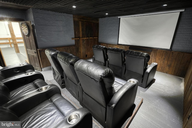 carpeted home theater room featuring wooden walls