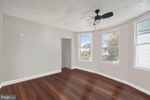 spare room with ceiling fan, a textured ceiling, and dark hardwood / wood-style flooring