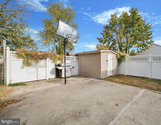 view of patio with a grill and a storage shed