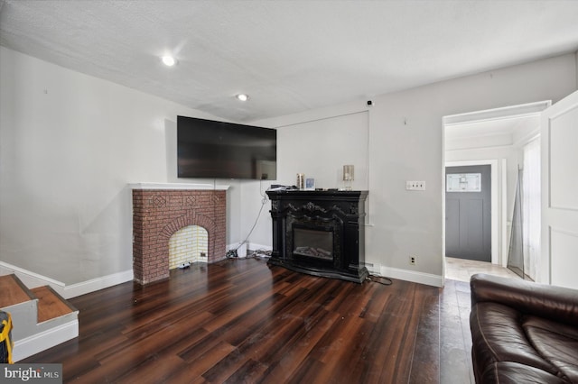 living room with dark hardwood / wood-style flooring and a textured ceiling