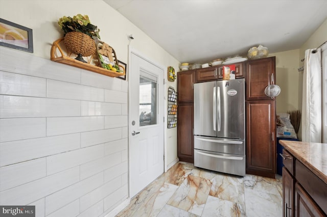 kitchen with dark brown cabinetry and stainless steel fridge