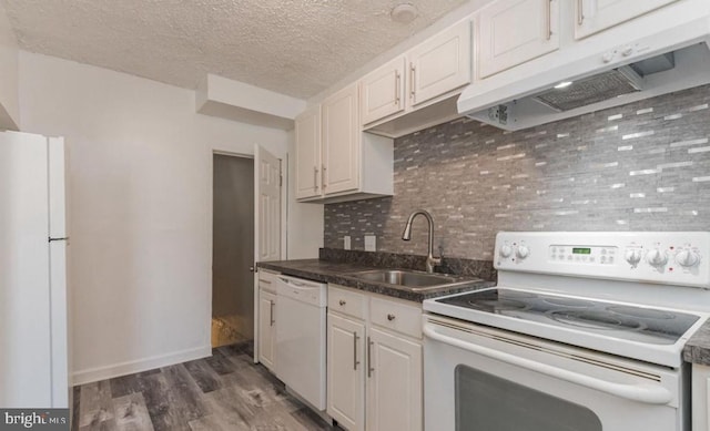 kitchen with decorative backsplash, sink, white cabinetry, white appliances, and dark hardwood / wood-style flooring