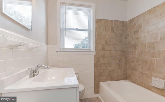 bathroom featuring vanity, toilet, a wealth of natural light, and a bathing tub