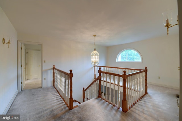 stairs featuring a chandelier and carpet flooring