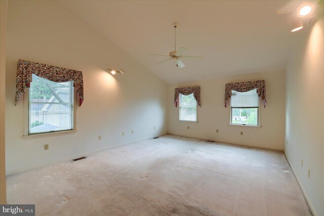 empty room featuring ceiling fan, lofted ceiling, and light colored carpet