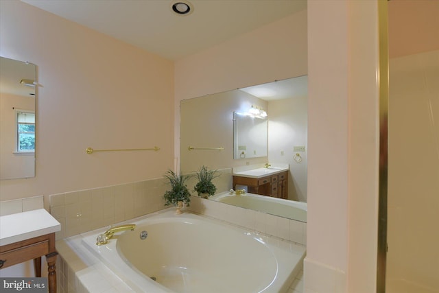 bathroom featuring vanity and tiled bath