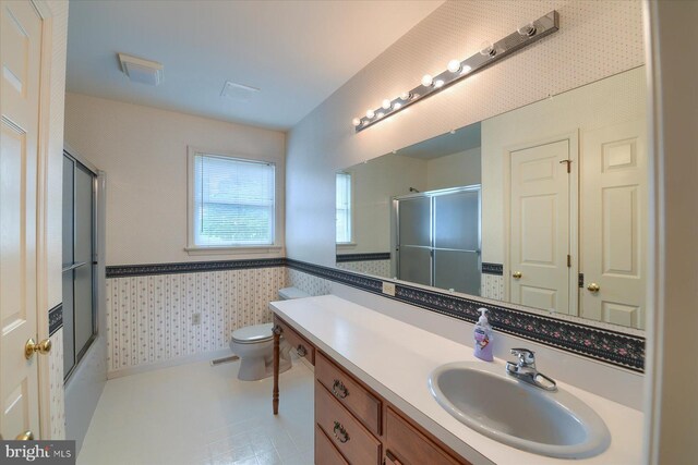 bathroom featuring toilet, vanity, and tile patterned flooring