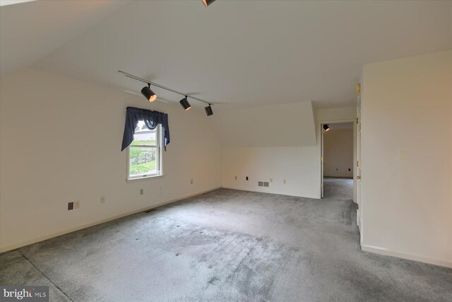 interior space with carpet floors and vaulted ceiling