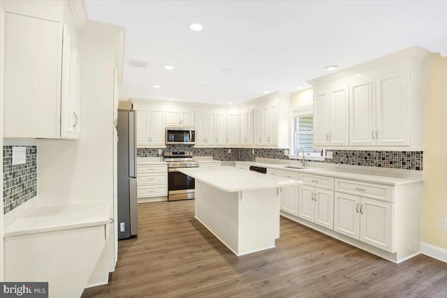 kitchen featuring a center island, white cabinets, hardwood / wood-style flooring, and stainless steel appliances