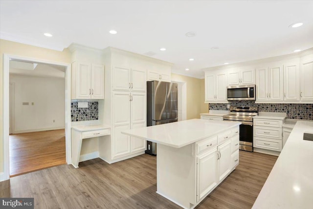 kitchen featuring appliances with stainless steel finishes, decorative backsplash, white cabinets, and light wood-type flooring