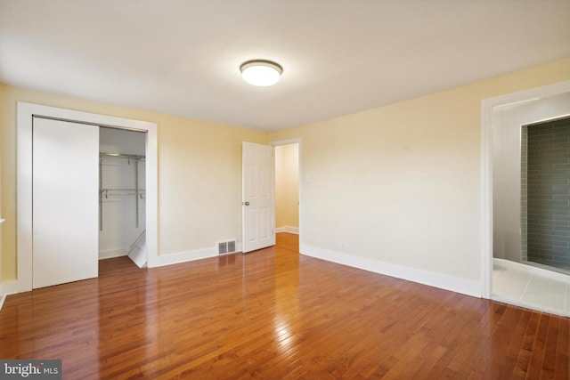 unfurnished bedroom with a closet and hardwood / wood-style floors