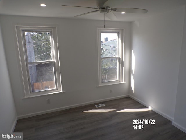 spare room with dark wood-type flooring, ceiling fan, and a wealth of natural light