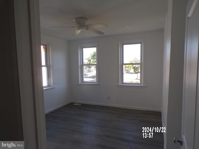 unfurnished room featuring dark wood-type flooring and ceiling fan