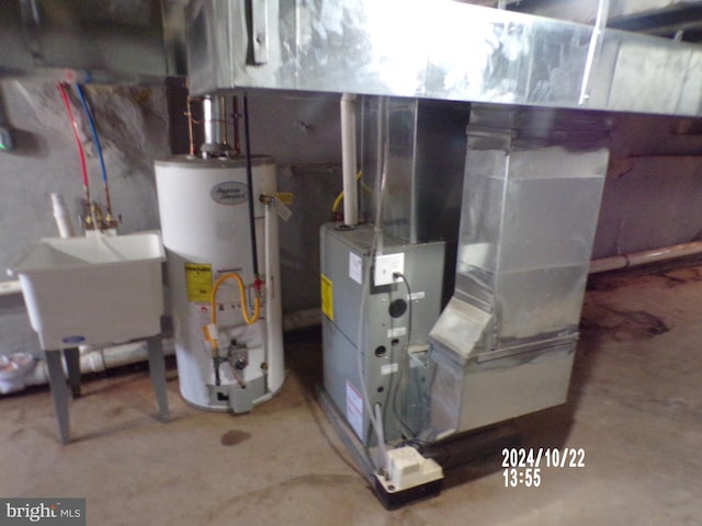 utility room featuring sink, gas water heater, and heating unit