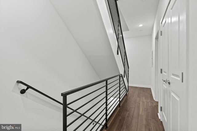 hallway featuring an upstairs landing, dark wood-style flooring, and baseboards