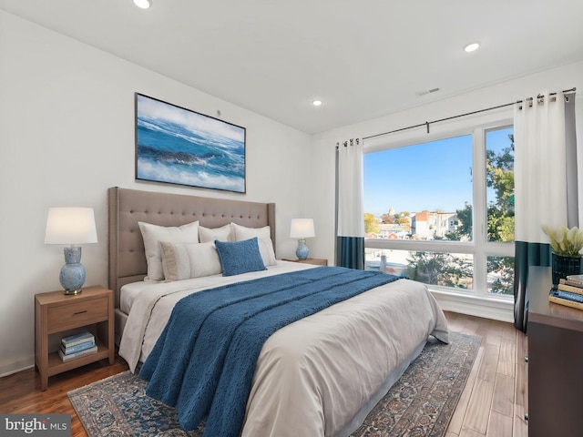 bedroom featuring recessed lighting, wood finished floors, and multiple windows