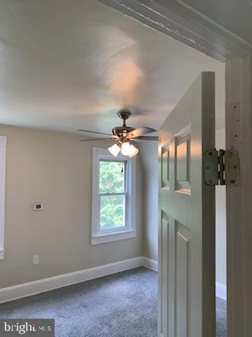 unfurnished room with ceiling fan and carpet