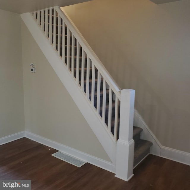 stairs featuring hardwood / wood-style floors