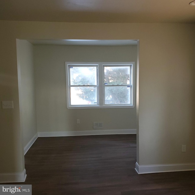 spare room featuring dark wood-type flooring