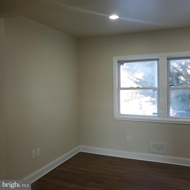 spare room with dark hardwood / wood-style flooring