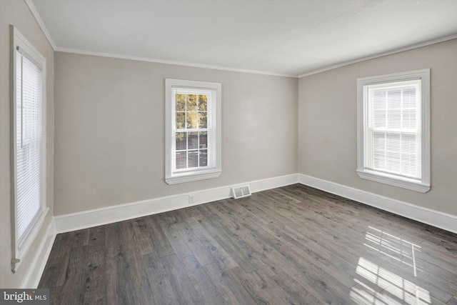 spare room with ornamental molding and dark wood-type flooring