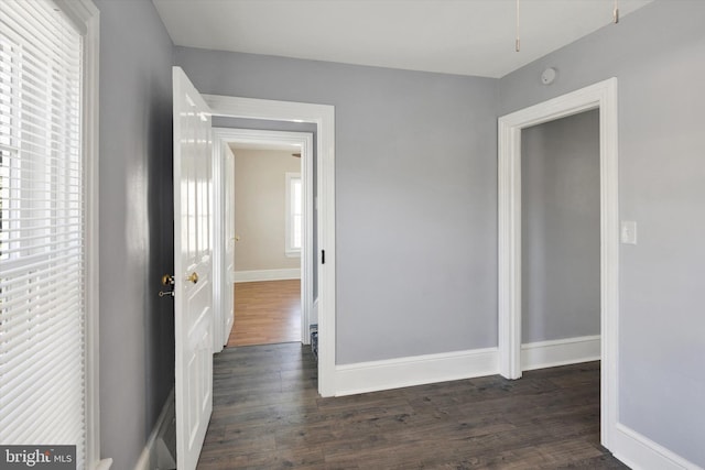 corridor with dark hardwood / wood-style flooring