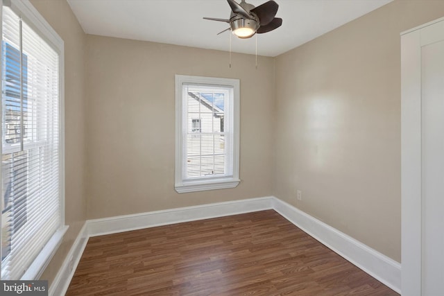 empty room with ceiling fan and dark hardwood / wood-style flooring