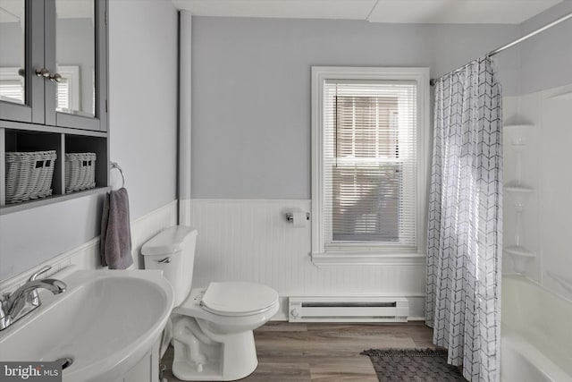 full bathroom featuring hardwood / wood-style flooring, toilet, baseboard heating, shower / bath combo with shower curtain, and vanity