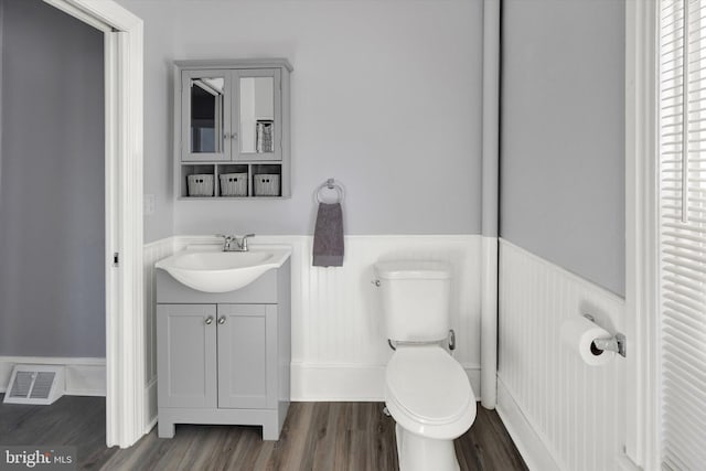 bathroom with vanity, toilet, and wood-type flooring