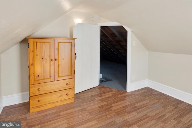 additional living space featuring lofted ceiling and hardwood / wood-style floors