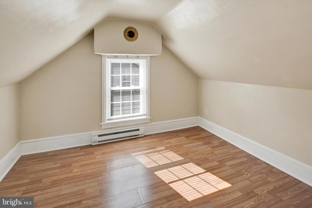 bonus room with light hardwood / wood-style floors, lofted ceiling, and a baseboard radiator