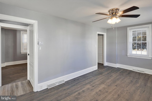 empty room with ceiling fan and dark hardwood / wood-style flooring