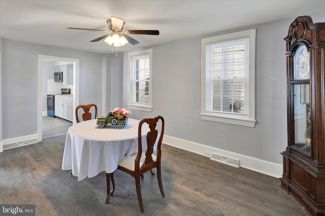 dining area with ceiling fan and dark hardwood / wood-style flooring