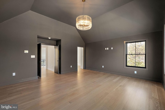 additional living space with lofted ceiling, light hardwood / wood-style flooring, and a chandelier