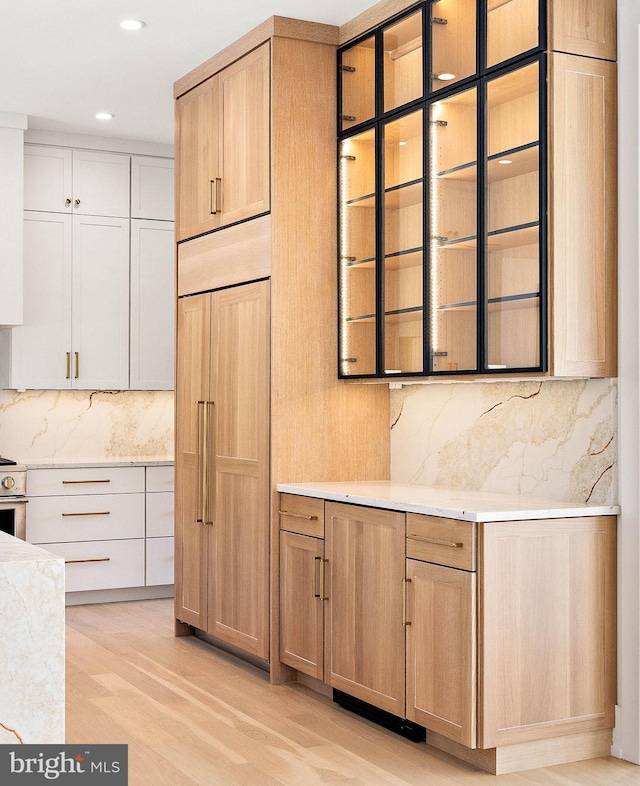 kitchen featuring white cabinetry, decorative backsplash, light wood-type flooring, and stainless steel electric stove