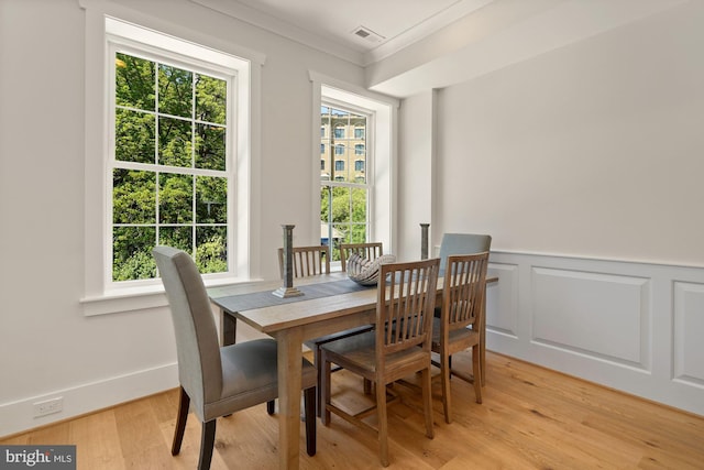 dining room featuring light hardwood / wood-style floors and crown molding