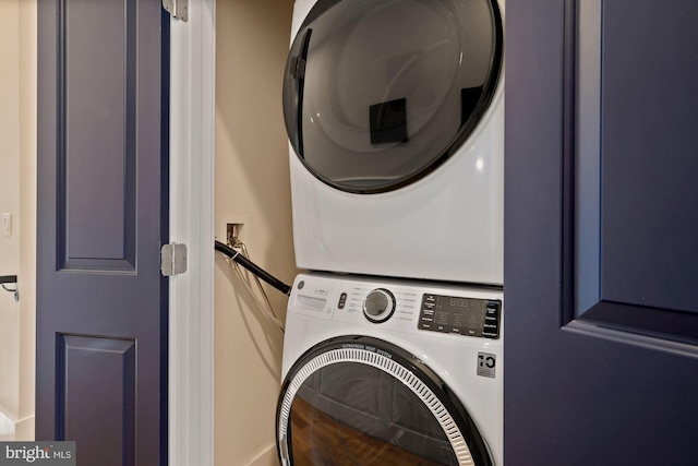 washroom featuring stacked washing maching and dryer