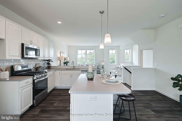 kitchen featuring dark wood-type flooring, appliances with stainless steel finishes, sink, and white cabinets