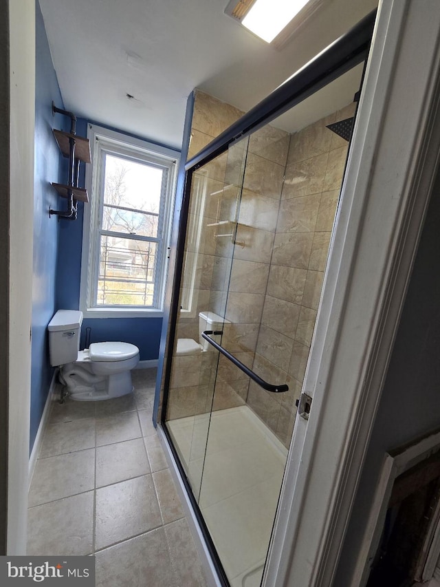 bathroom with tile patterned floors, toilet, and walk in shower