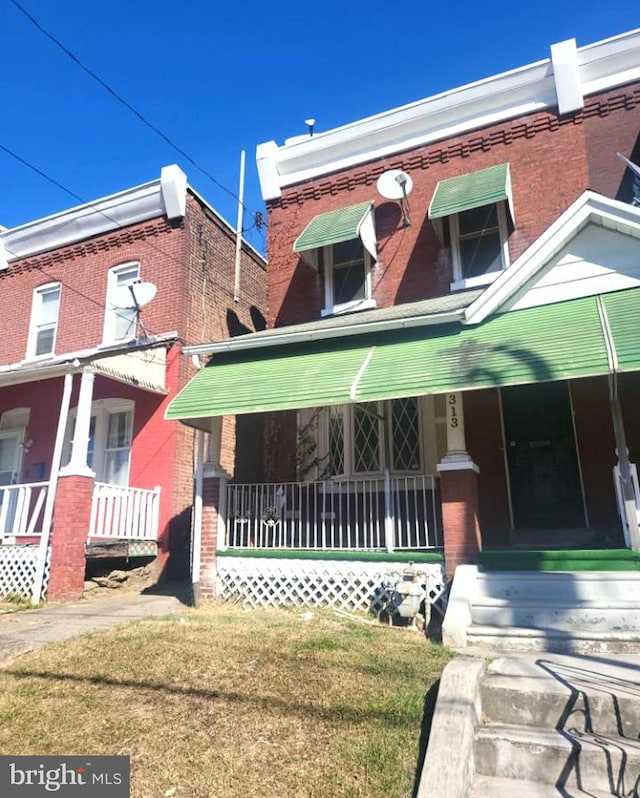 view of front of home featuring covered porch and a front yard