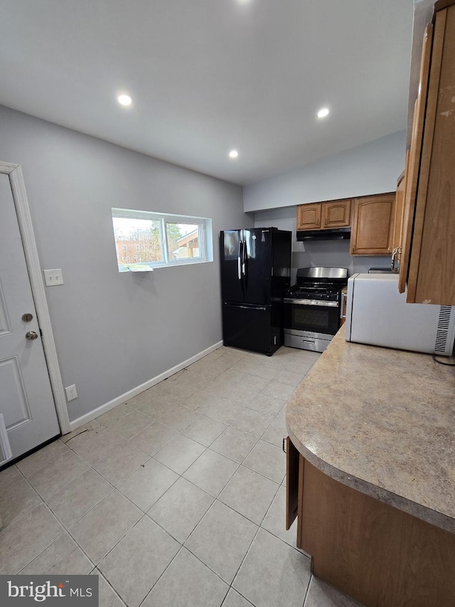 313 Pennell St, Chester, PA 19013 - kitchen featuring recessed lighting, freestanding refrigerator, under cabinet range hood, brown cabinets, and gas stove