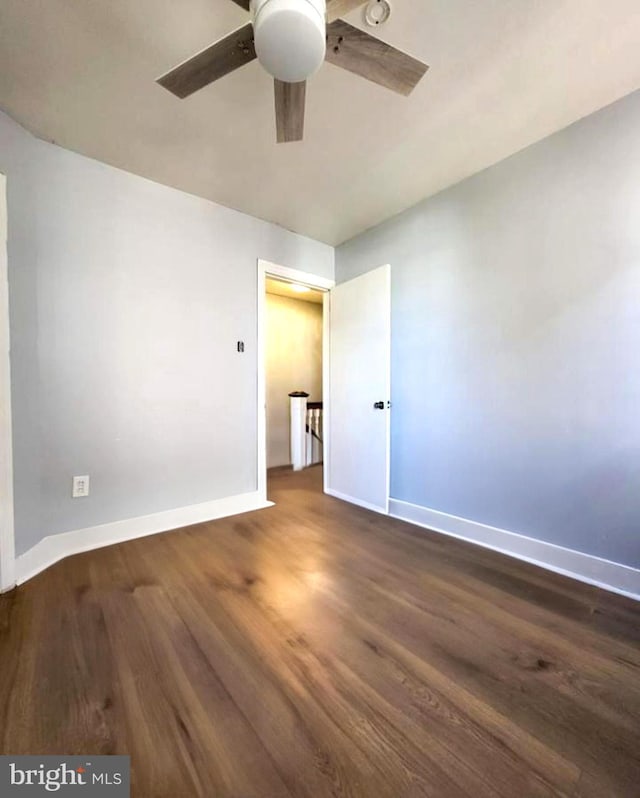 spare room with ceiling fan and dark wood-type flooring