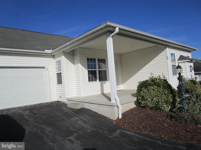 view of side of home with covered porch and a garage