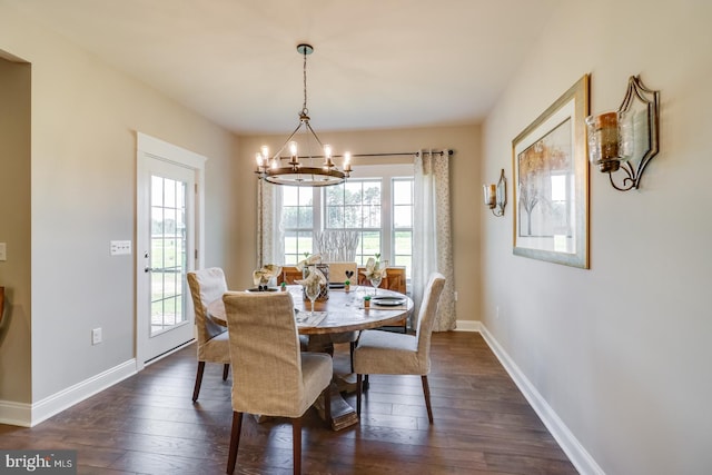 dining room with dark wood-type flooring and a notable chandelier