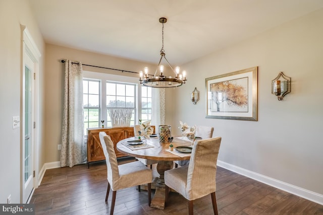 dining space featuring dark wood-type flooring and a notable chandelier