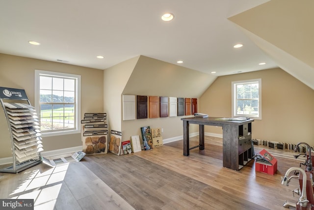 bonus room featuring a healthy amount of sunlight, light wood-type flooring, and vaulted ceiling